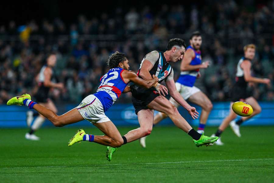 Western Bulldogs' Artie Jones lays a tackle on future teammate Zak Butters.