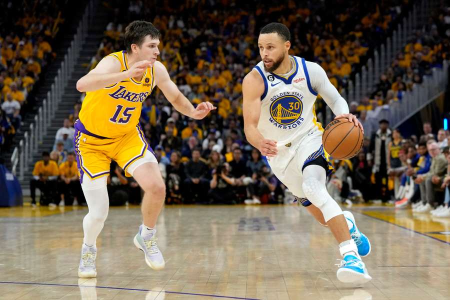 Stephen Curry de la Golden State Warriors trece de Austin Reaves de la Los Angeles Lakers