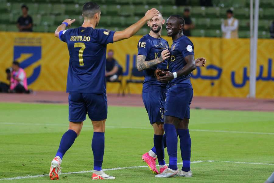 Al-Nassr's Cristiano Ronaldo (L), Marcelo Brozovic (C) and Sadio Mane celebrate