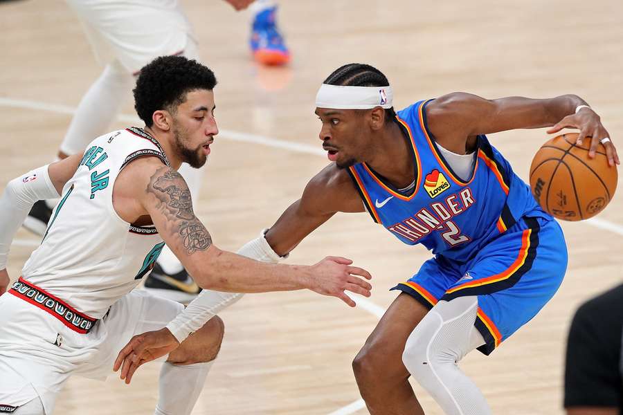Shai Gilgeous-Alexander of the Oklahoma City Thunder with the ball against Scotty Pippen Jr. of the Memphis Grizzlies