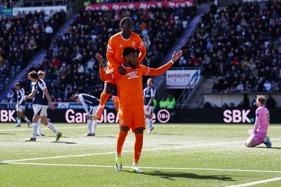 Youssef Chermiti of Rangers celebrates scoring his team's fifth goal with teammate Djeidi Gassama