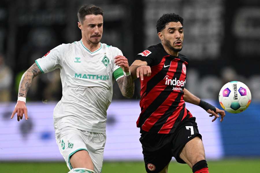 Marco Friedl (L) of Bremen and Omar Marmoush of Frankfurt fight for the ball