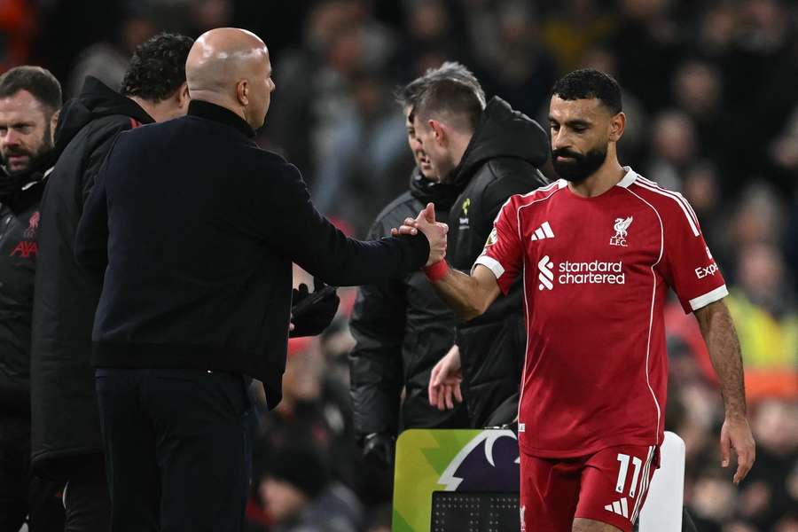 Slot (L) shakes hands with Salah