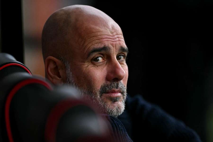 O treinador espanhol Pep Guardiola senta-se no banco de suplentes antes do jogo de futebol da Premier League inglesa entre o Bournemouth e o Mancheste