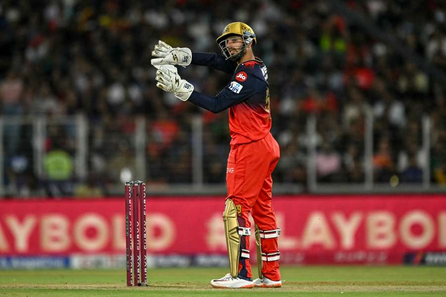 Royal Challengers Bengaluru's Jitesh Sharma adjusts the field 