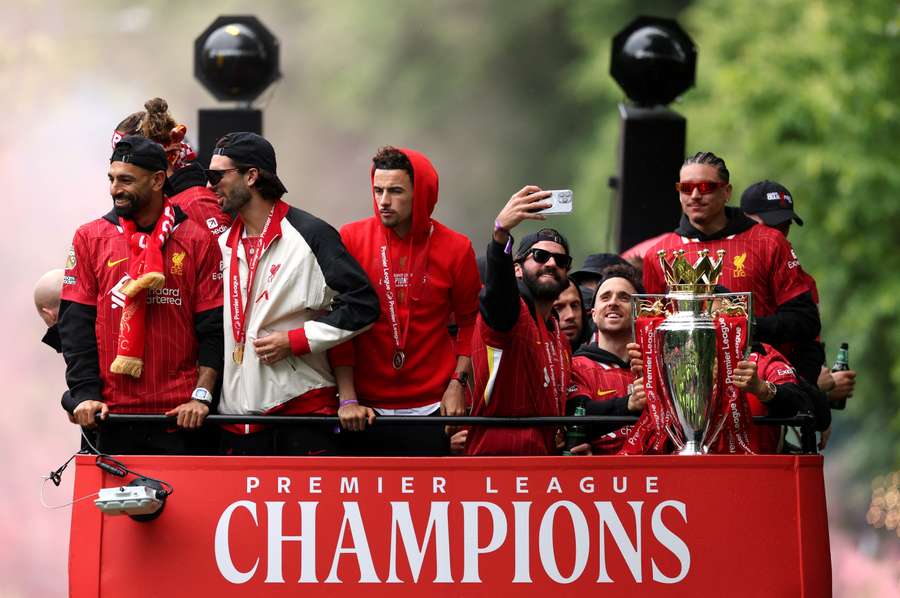 Jota (2nd R) poses with the trophy during Liverpool's title parade