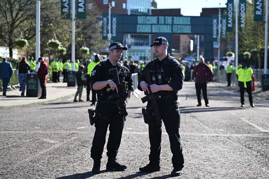 Armed police patrol outside the racecourse ahead of the final day of the Grand National Festival