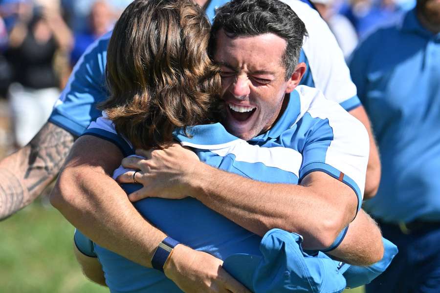 Rory McIlroy celebrates with Tommy Fleetwood after their 2&1 win over USA's Xander Schauffele and Patrick Cantlay in their foursomes match