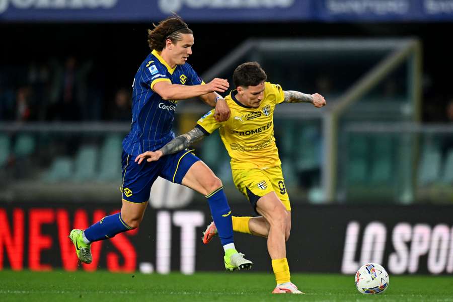 Daniele Ghilardi del Hellas Verona disputa el balón con Dennis Man