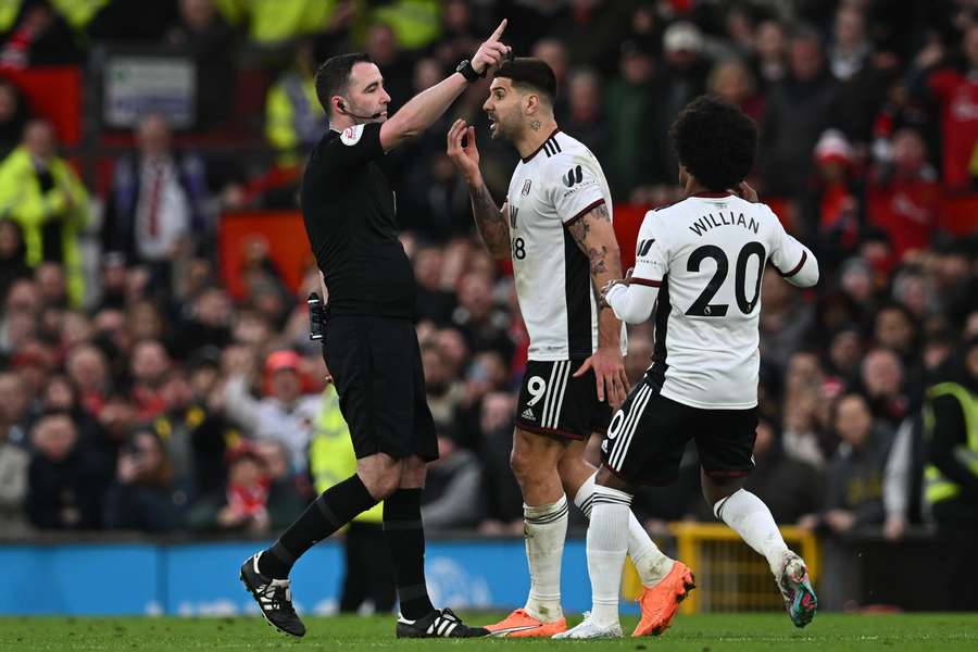 Fulham's Serbian striker Aleksandar Mitrovic (C) is restrained by Willian (R) after being shown a red card