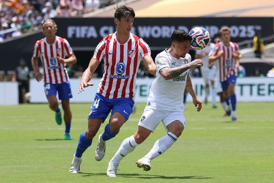 Atletico Madrid's Robin Le Normand battles for the ball with Jefferson Savarino