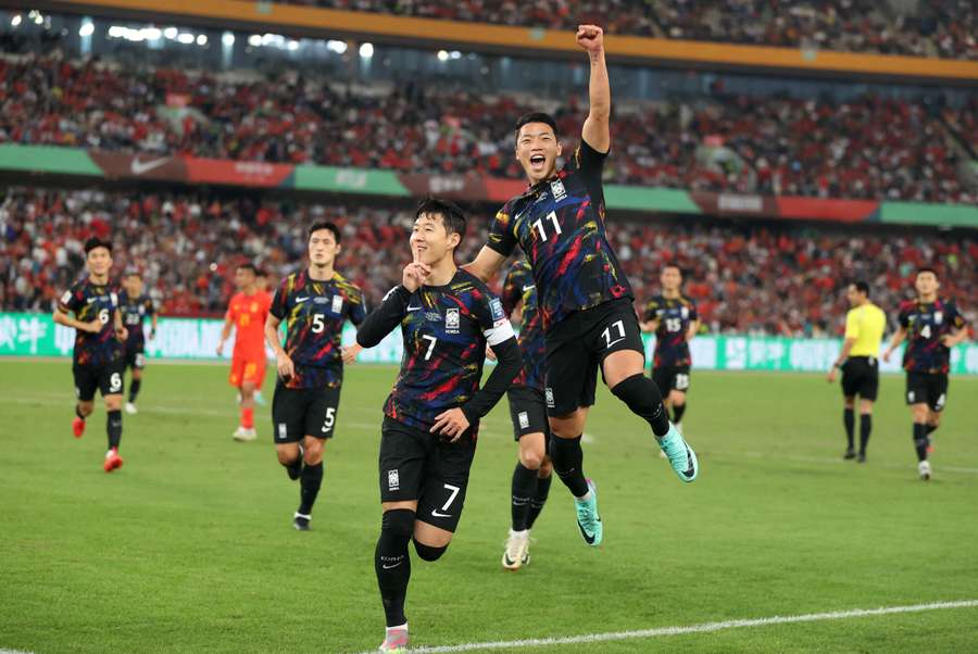 Son Heung-min (L) viert een doelpunt tegen China