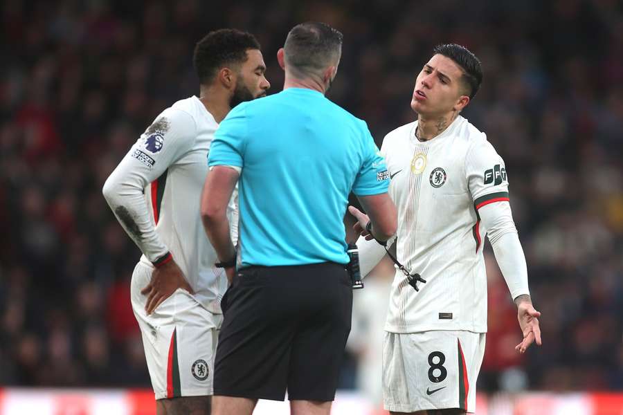 Chelsea players speak with referee Michael Oliver