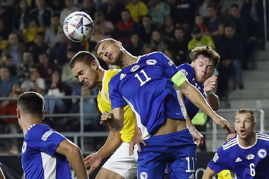 Edin Dzeko, în duel aerian cu George Pușcaș, în partida dintre România și Bosnia din Liga Națiunilor 2022/2023, încheiat cu 4-1 pentru tricolori
