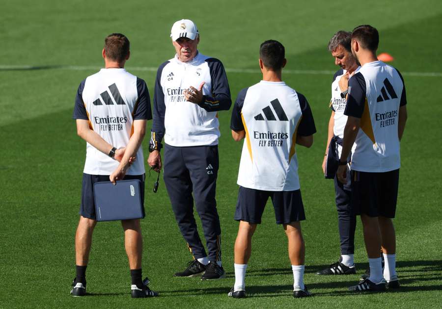 Real Madrid's Italian coach Carlo Ancelotti (2L) chats with his staff during a training session