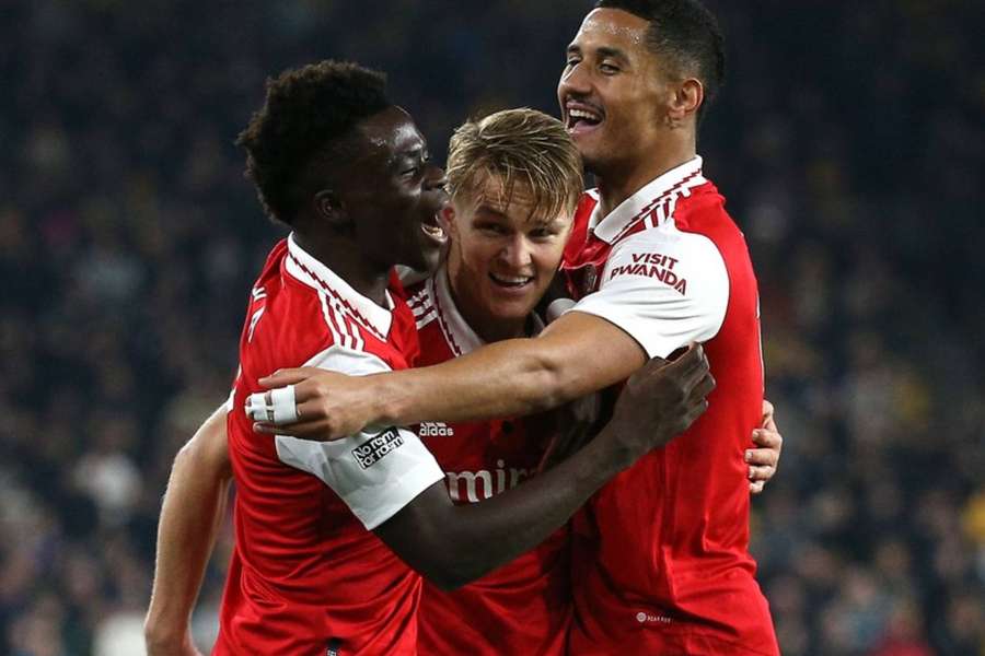 Martin Odegaard celebrates his opening goal with Bukayo Saka and William Saliba.