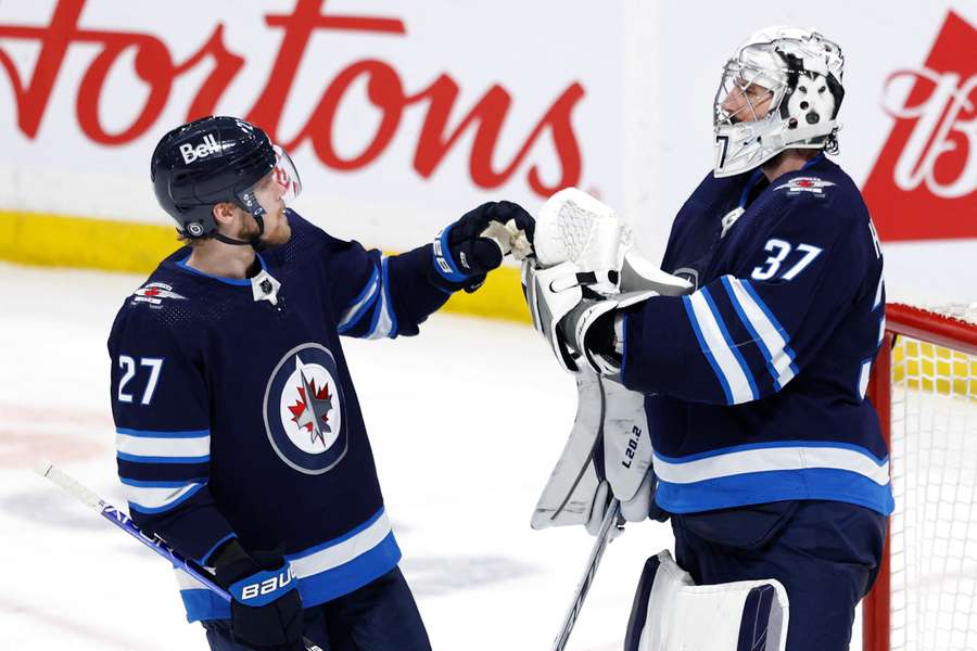 Nikolaj Ehlers og målmand Connor Hellebuyck fejrer sejren over Pitteburgh Penguins