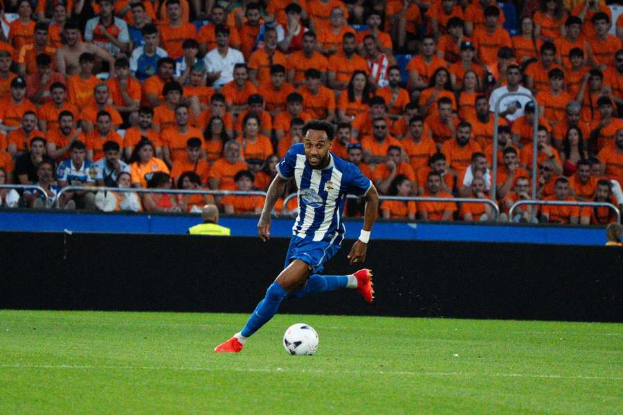 Detrás de Aubameyang, aficionados del Deportivo vestidos de naranja como protesta contra el club Detrás de Aubameyang, aficionados del Deportivo vestidos de naranja como protesta contra el club