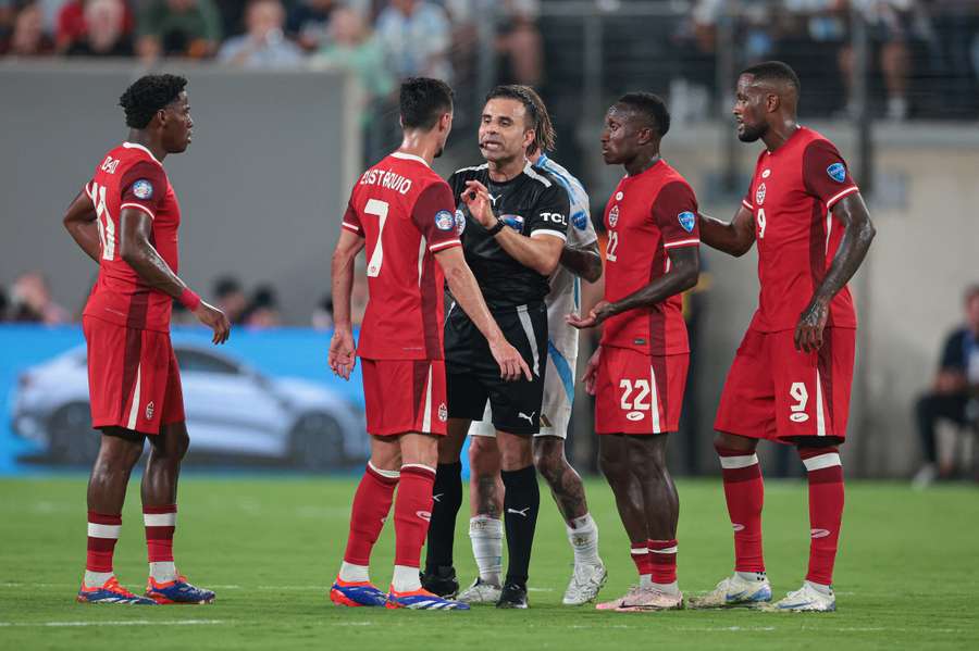 Canada players argue with the referee during their semi-final