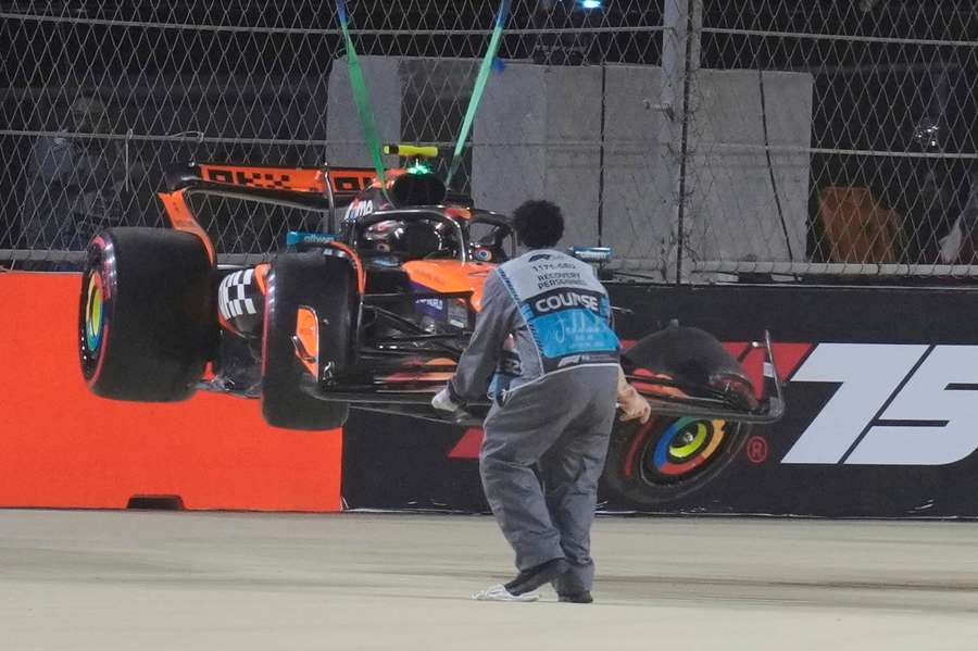 Lando Norris' car is carried out off the track after he crashed during qualifying