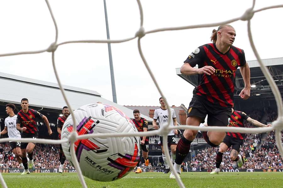 Manchester City's Norwegian striker Erling Haaland (R) celebrates after scoring the opening goal from the penalty spot against Fulham