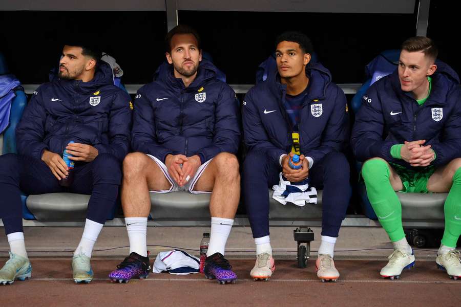 England captain Harry Kane sits in the dugout next to Morgan Gibbs-White, Jarell Quansah and Dean Henderson ahead of their match against Greece