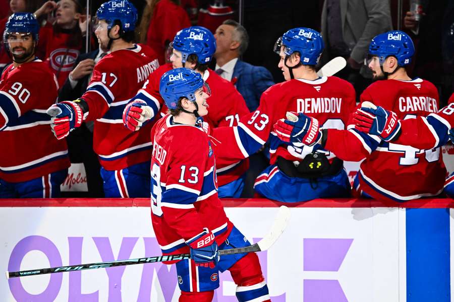 Cole Caufield celebrates a goal with teammates
