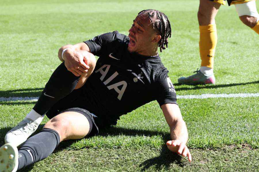 Spurs' Xavi Simons grabs his knee during the Premier League game against Wolves