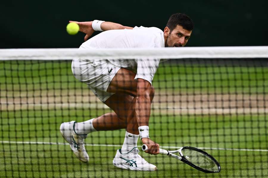 Novak Djokovic din Serbia returnează mingea către Jannik Sinner din Italia în timpul meciului de tenis din semifinala de simplu masculin
