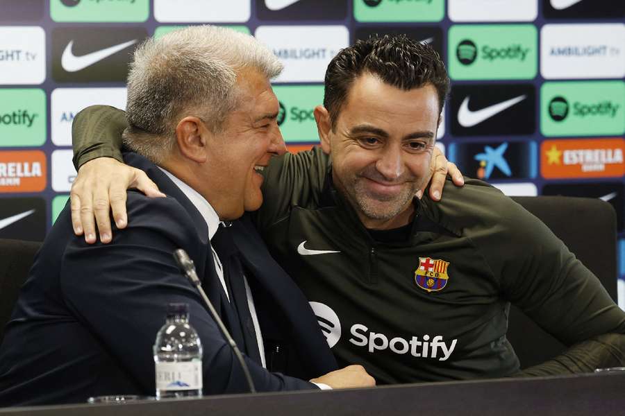 O treinador (dir.) abraça o presidente Laporta em coletiva na Espanha