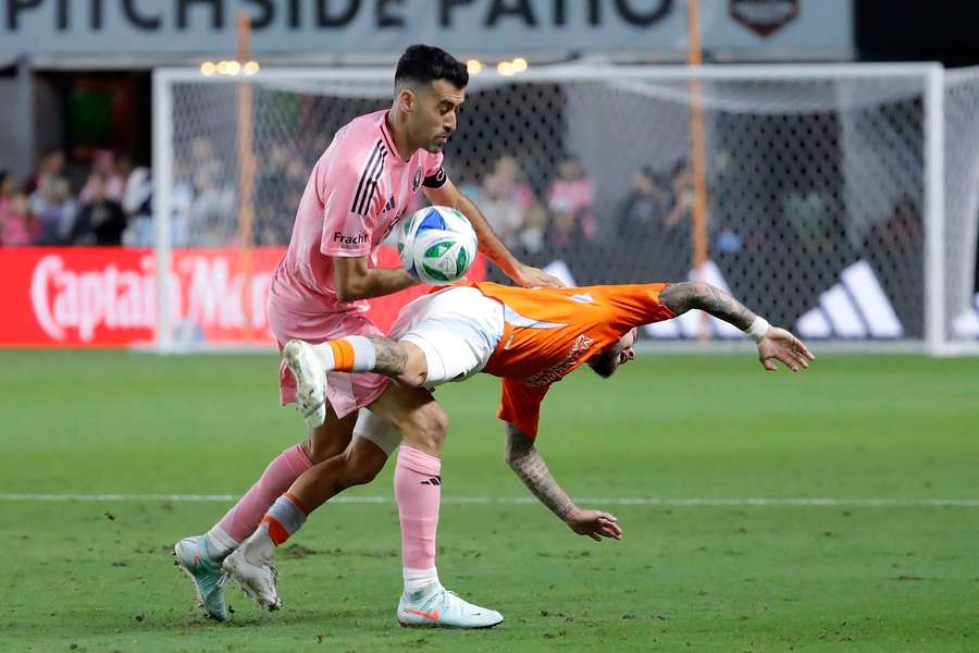 Busquets frena a un rival.