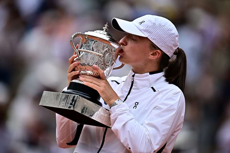 Iga Swiatek kisses the Suzanne Lenglen trophy after beating Karolina Muchova to win the French Open title for the third time