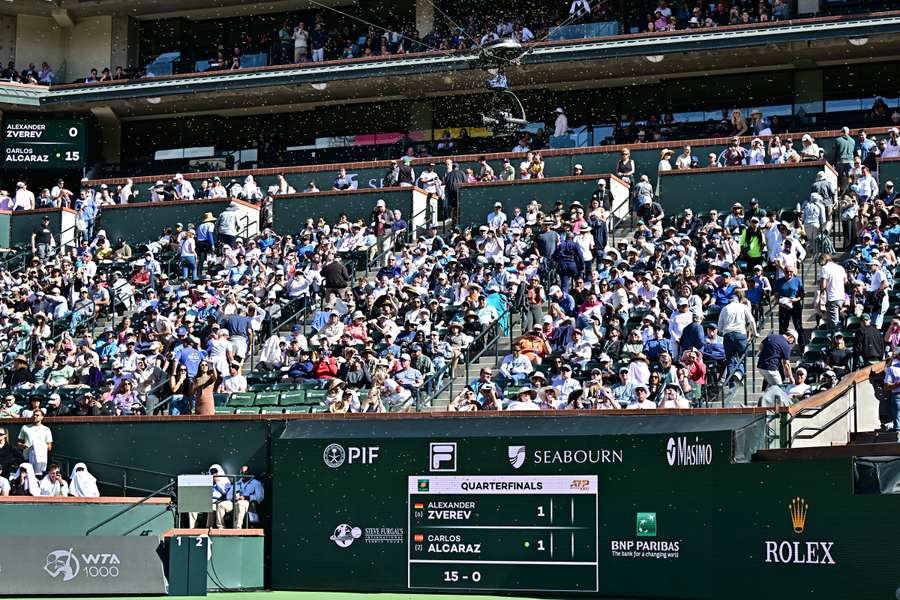 Spectators remain seated during a suspension of the match between Carlos Alcaraz and Alexander Zverev after an attack by a swarm of bees