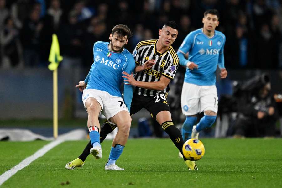 Khvicha Kvaratskhelia of Napoli is challenged by Carlos Alcaraz of Juventus