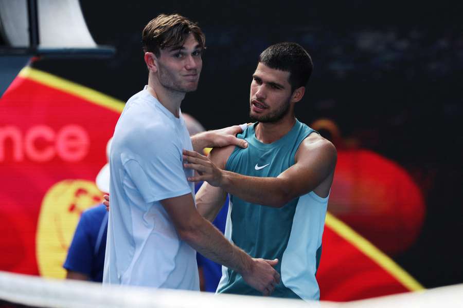 El británico Jack Draper abraza al español Carlos Alcaraz al retirarse de su partido individual masculino en la octava jornada del Abierto de Australi
