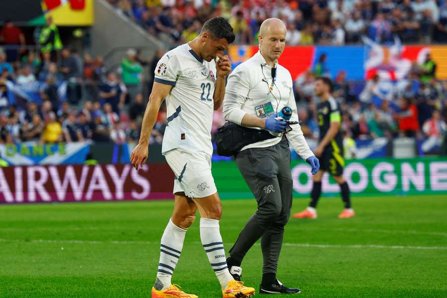 Fabian Schar is treated for his broken nose during the Scotland game