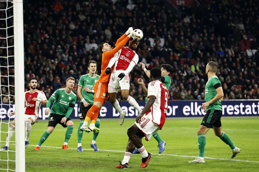 PEC-goalie Jasper Schendelaar in een luchtduel met Chuba Akpom van Ajax