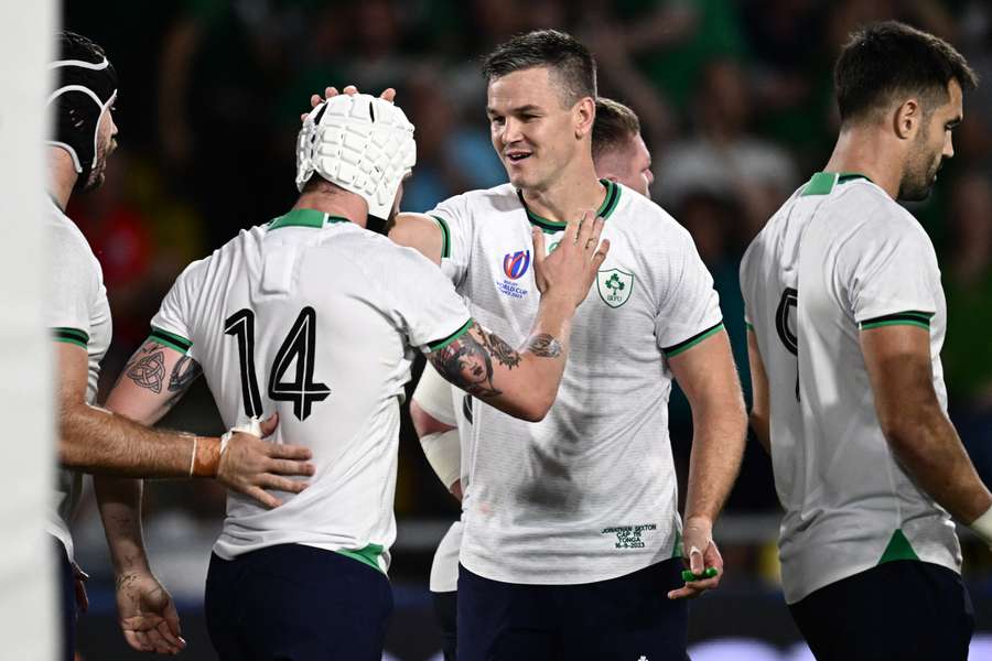 Ireland wing Mack Hansen (2L) is congratulated by fly-half Jonathan Sexton (C) after scoring a try