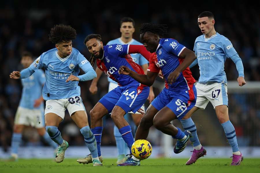 Jairo Riedewald en David Ozoh van Crystal Palace in actie tegen Halid Djankpata van Manchester City