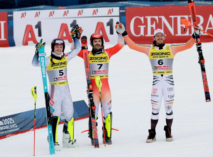 Loic Meillard celebrates after winning the slalom alongside second-placed Atle Lie McGrath and third-placed Linus Strasser