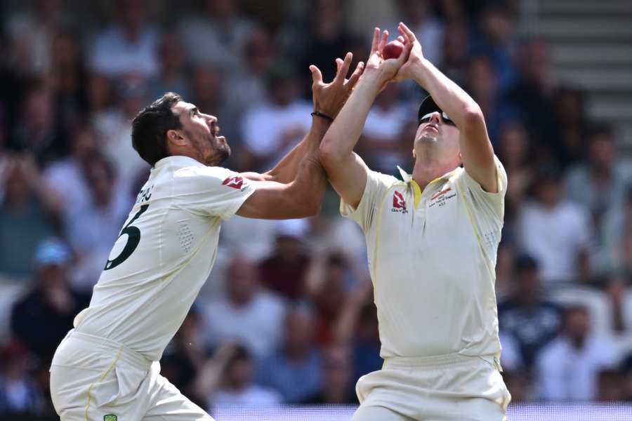 Australia's Mitchell Starc, left, closes in as Australia's Pat Cummins,right, takes a catch to dismiss England's Harry Brook