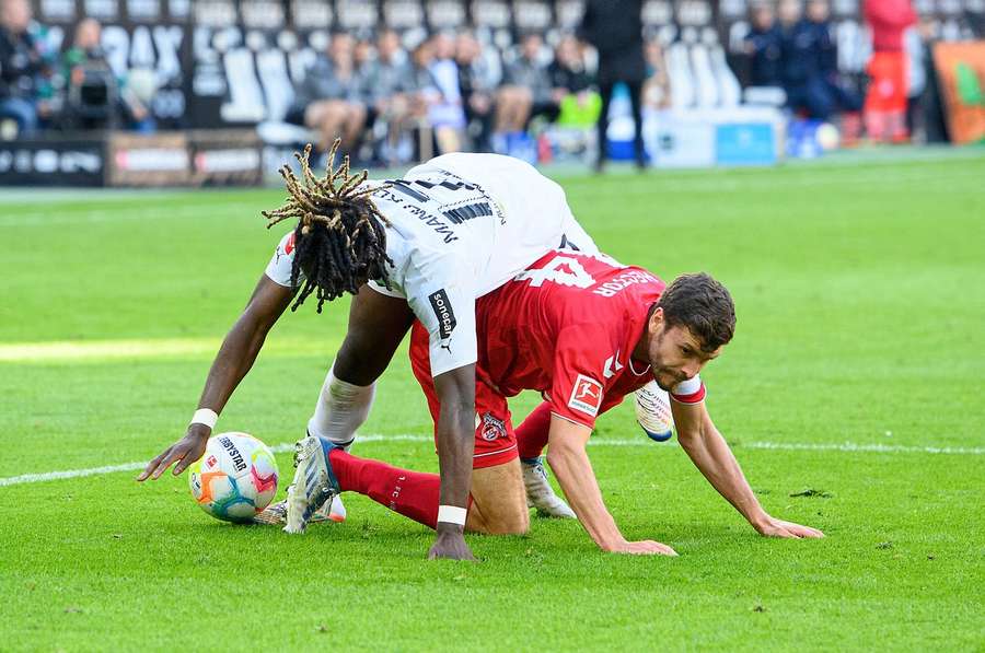 Ein Duell auf Augen- und Grasnarbenhöhe. Mönchengladbachs Manu Kone (weiß) im Duell mit Kölns Jonas Hector (rot).