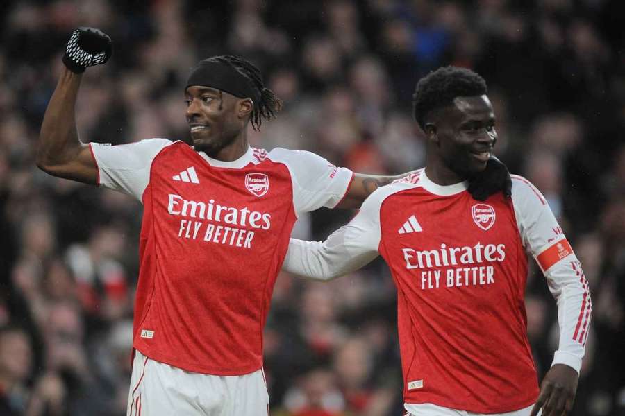 Madueke (L) and Saka celebrate Arsenal's win over Wigan