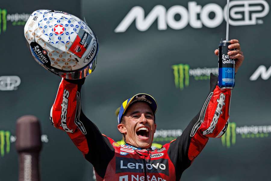 Marc Marquez celebrates on the podium after winning the race