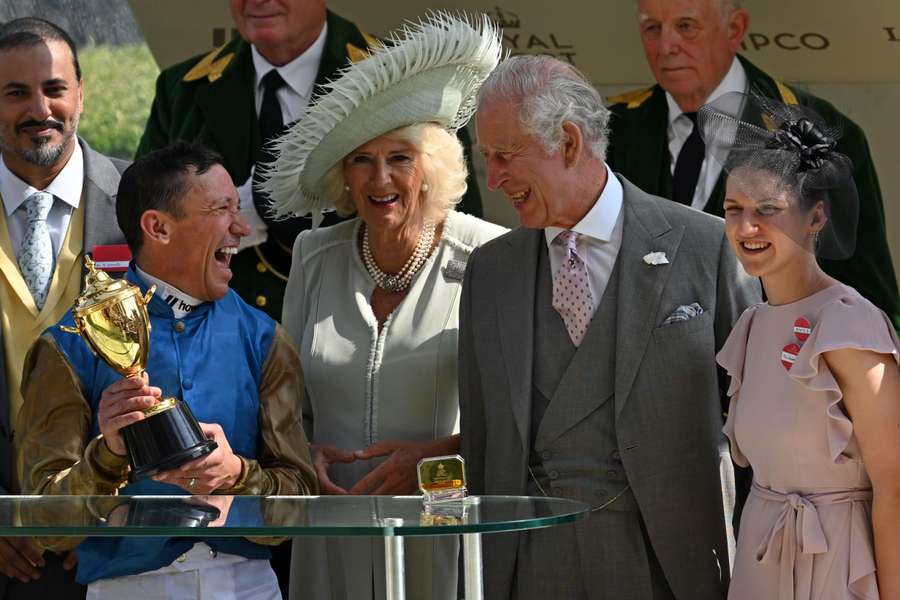Jockey Frankie Dettori (2L) shares a joke with Britain's King Charles III (2R) as he celebrates with the Gold Cup trophy