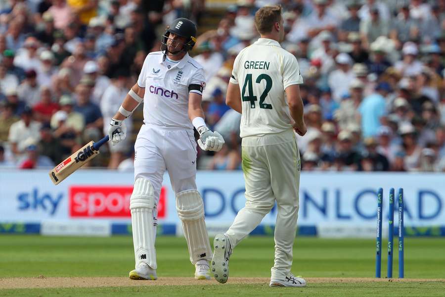 England's Stuart Broad reacts after losing his wicket off the bowling of Australia's Cameron Green (R) on the opening day