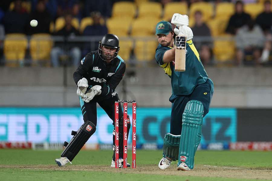Australia's Tim David (R) plays a shot as New Zealand's wicketkeeper Devon Conway reacts