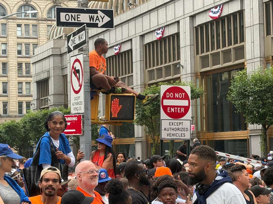 Des supporters ont grimpé sur les feux, les panneaux et les échafaudages pour voir les champions NBA