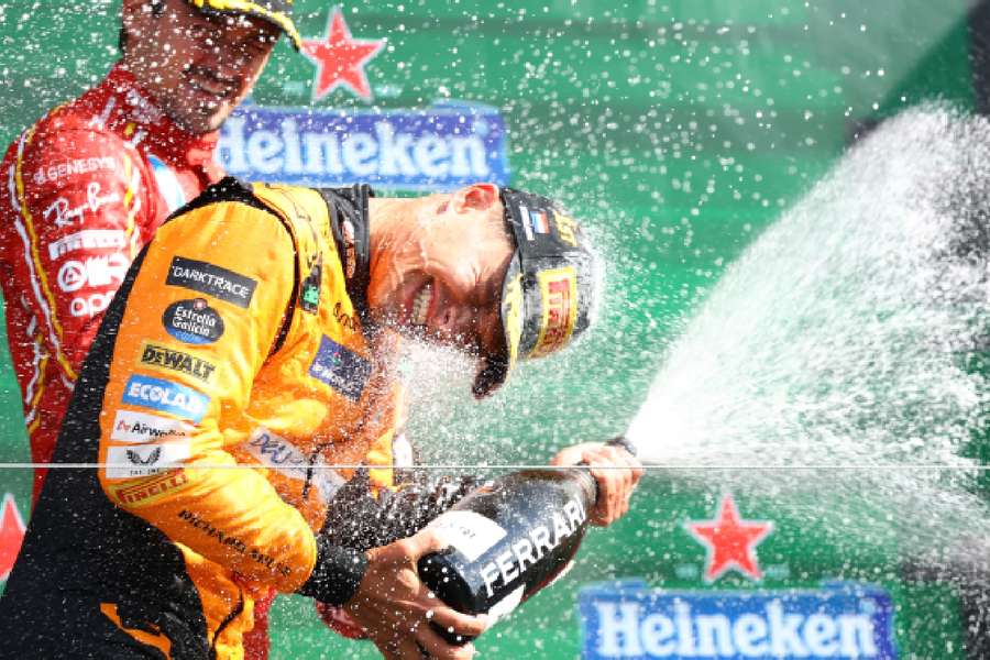 McLaren's Lando Norris celebrates with champagne on the podium after winning the Dutch Grand Prix