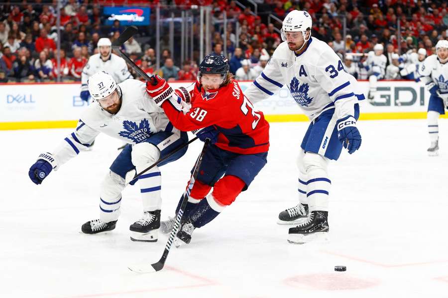 Washington Capitals' Rasmus Sandin battles for the puck between Toronto Maple Leafs' Timothy Liljegren and Maple Leafs centre Auston Matthews